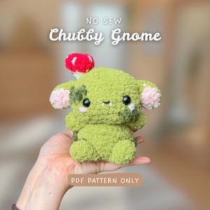 Könnte beinhalten: Ein handgemachter grüner Plüschzwerg mit rotem Pilzhut und rosa Akzenten. Der Text "NO SEW Chubby Gnome" steht über dem Zwerg, und "PDF PATTERN ONLY" darunter.