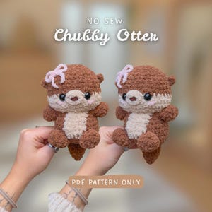 May include: Two handmade brown and beige crocheted otter plushies with pink bows. The otters have black eyes and are labeled "Chubby Otter" and "PDF Pattern Only".