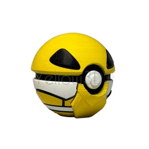 May include: A yellow and black spherical object with white and black accents. The object has a circular design on the side and the text "Yellow 3D" is visible. The object is likely a toy or collectible.
