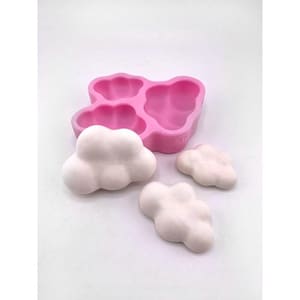 May include: Pink silicone mold with three cloud-shaped cavities. Three white cloud-shaped objects are shown next to the mold.