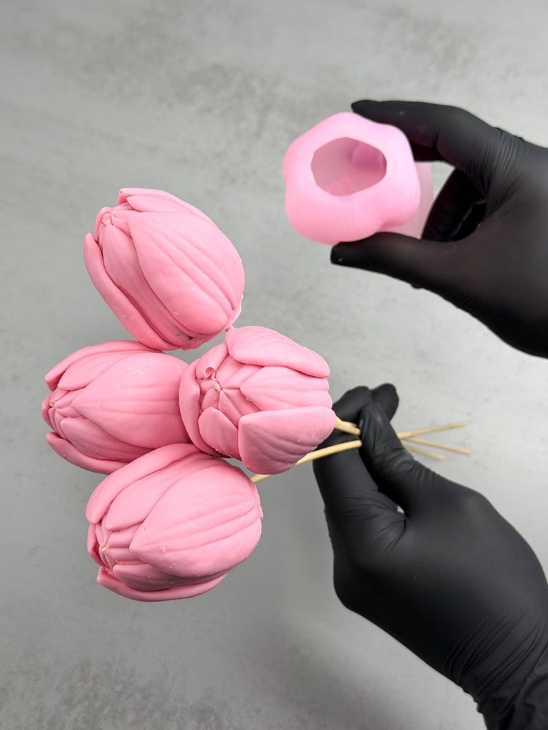 Pu&ograve; includere: Stampi a forma di tulipano rosa e fiori finiti. I fiori sono su spiedini di legno e gli stampi sono tenuti in una mano guantata. I fiori sono di un rosa tenue e gli stampi sono di una tonalit&agrave; di rosa pi&ugrave; chiara.