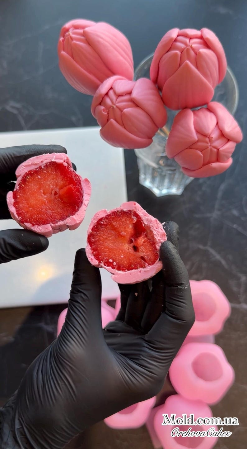 May include: Pink tulip-shaped sweets and strawberry halves coated in pink. The image shows several pink tulip-shaped sweets, some in a glass, and two strawberry halves coated in pink. The text "Mold.com.ua Orchova Cakes" is visible.