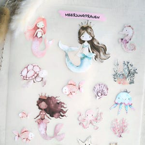 Könnte beinhalten: Ein Bogen Aufkleber mit Aquarellillustrationen von Meerjungfrauen und Meeresbewohnern. Die Aufkleber zeigen Meerjungfrauen, Seepferdchen, Fische, Quallen und eine Schatztruhe. Der Text "MEERJUNGFRAUEN" ist sichtbar.