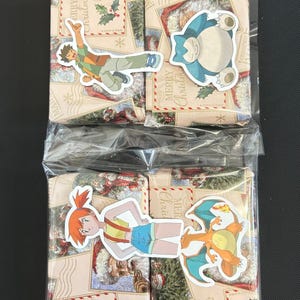 May include: Two wrapped gift boxes with Pokemon character stickers. The boxes have a Christmas theme with "Merry Christmas" text and illustrations. One box has a sticker of Misty, and the other has a sticker of Charizard.