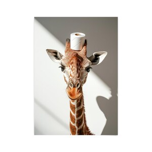 May include: A giraffe with a white toilet paper roll on its head, looking directly at the camera. The giraffe has brown and white spots and a long neck. The background is white.