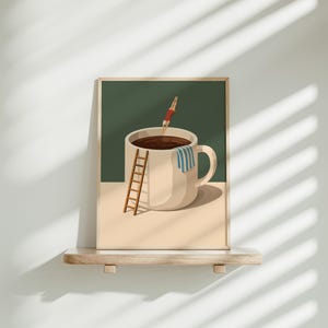 May include: A framed art print depicts a large coffee cup filled with dark liquid. A person in a red swimsuit dives into the cup. A small wooden ladder leans against the cup, and a blue and white striped towel hangs on the handle.