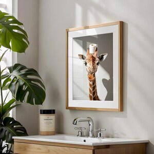 May include: A framed photograph of a giraffe with a toilet paper roll on its head. The giraffe is looking directly at the camera. The photo is in a wooden frame.