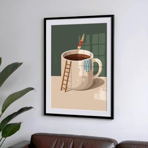 May include: A framed art print depicts a whimsical scene of a person diving into a giant coffee mug filled with dark liquid. A small wooden ladder leans against the mug, and a striped towel hangs on the handle. The background is a muted green.