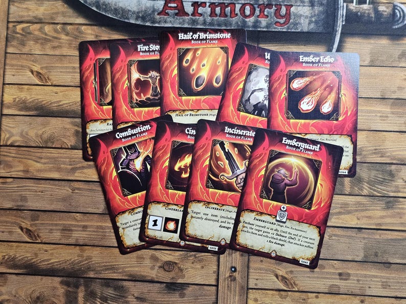 May include: A collection of fantasy-themed game cards with red and orange borders, featuring illustrations of fire and magical elements. The cards have titles like "Fire Stor," "Hail of Brimstone," and "Ember Echo." The cards are arranged on a wooden surface.