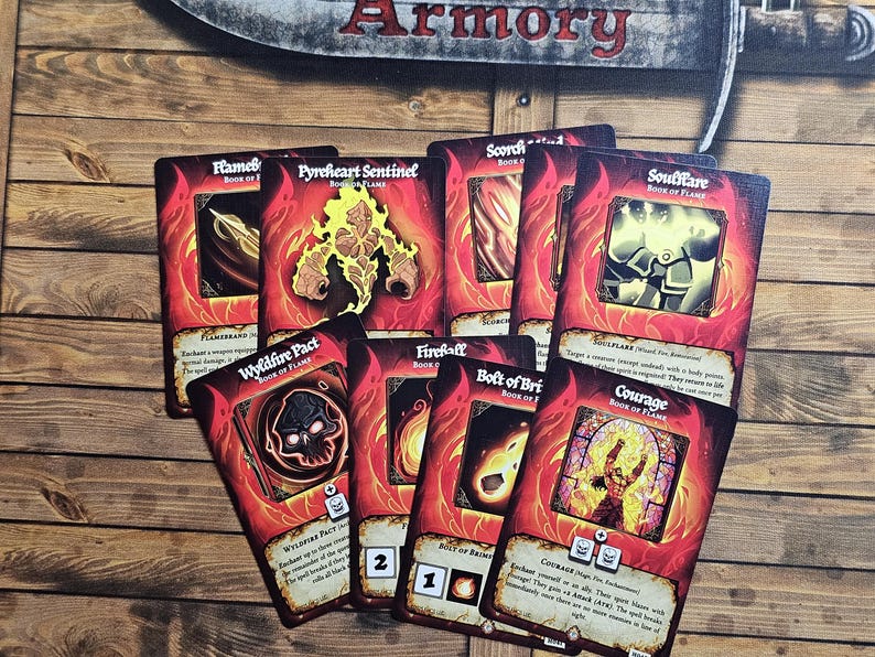 May include: A collection of fantasy-themed game cards with red and orange flames. The cards feature illustrations and text, including "Wyldfire Pact" and "Courage". The cards are arranged on a wooden surface.