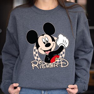 a woman wearing a mickey mouse sweatshirt