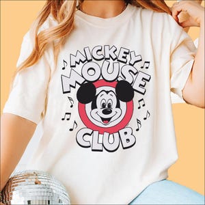 a woman wearing a mickey mouse t - shirt