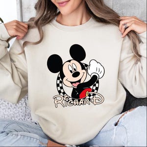 a woman wearing a sweatshirt with a mickey mouse graphic on it