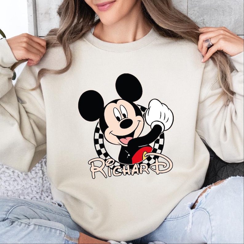 a woman wearing a sweatshirt with a mickey mouse graphic on it