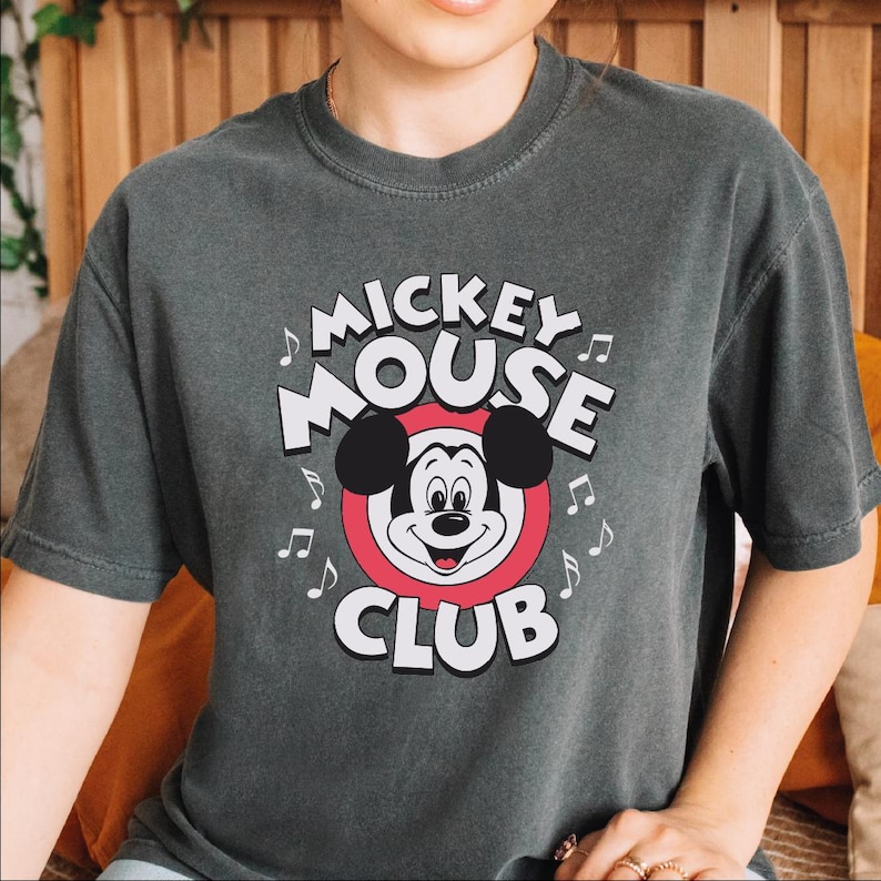 a young boy wearing a mickey mouse t - shirt