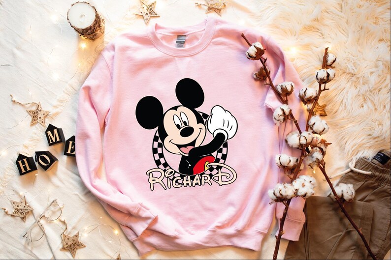 a pink sweatshirt with a mickey mouse on it
