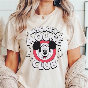 a woman wearing a mickey mouse club t - shirt