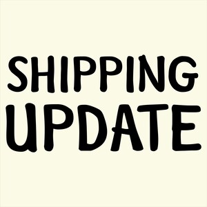Op de afbeelding: Zwarte tekst op een crèmekleurige achtergrond leest "SHIPPING UPDATE" in een vetgedrukte, handgeschreven stijl. De woorden zijn gecentreerd en beslaan het grootste deel van het frame, met een eenvoudig, strak ontwerp.