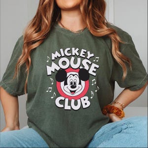 a woman wearing a mickey mouse club shirt