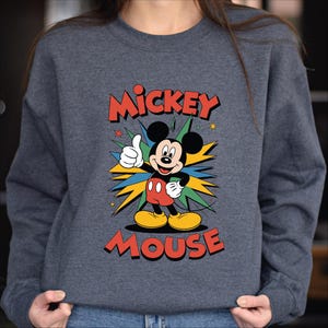 A gray sweatshirt with a colorful graphic of Mickey Mouse and the text "MICKEY MOUSE" printed on it.