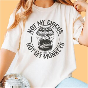 a woman wearing a white shirt with a monkey on it