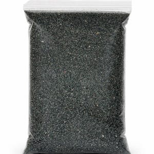 May include: A clear plastic bag filled with dark gray, granular material. The bag is sealed at the top with a white, ridged closure. The contents appear to be small, evenly sized particles, possibly for gardening or crafts.