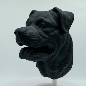 Könnte beinhalten: Eine schwarz-weiße 3D-gedruckte Skulptur eines Hundekopfes. Der Hund hat ein kurzes, glattes Fell und schaut nach rechts. Die Skulptur ist auf einem weißen Sockel montiert.