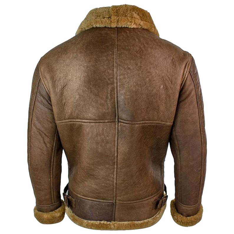 May include: A brown leather jacket with a shearling collar and lining. The jacket has a classic bomber style with a zip closure, two front pockets, and buckle details at the waist. The jacket is made of distressed leather.