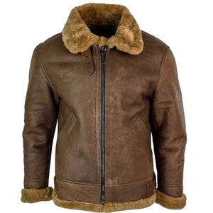 May include: A brown leather bomber jacket with a shearling collar and cuffs. The jacket features a full-length zipper, two front pockets, and a buckle detail at the waist. The jacket is a classic style, suitable for cold weather.