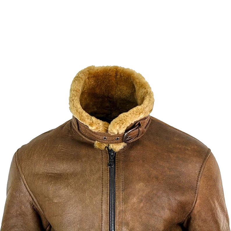 May include: Brown leather jacket with a shearling collar and lining. The jacket features a buckled collar strap and a black zipper closure. The leather has a distressed appearance, and the shearling is a light brown color.