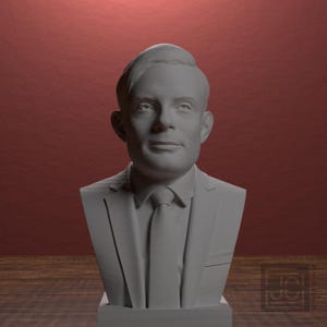 May include: A white bust of a man wearing a suit and tie. The sculpture is set against a red background and rests on a wooden surface. The bust is a detailed representation of a person's head and shoulders.