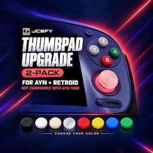 Puede incluir: Un paquete de 2 mejoras de thumbpad para consolas portátiles AYN y Retroid. La imagen muestra un dispositivo de juego azul con un thumbpad rosa texturizado instalado y una fila de ocho cubiertas circulares en negro, blanco, beige, transparente, rojo, amarillo, azul y verde.