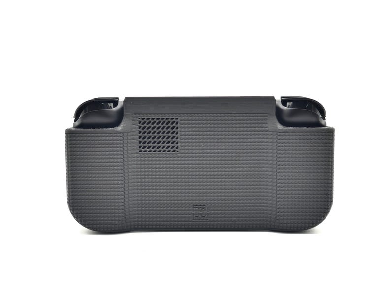 May include: A dark gray handheld gaming device case with a textured surface. The case has two black handles and a vent. The case is designed to protect the gaming device.
