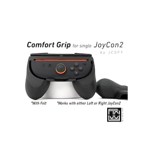 May include: Black Comfort Grip for a single JoyCon2 controller. The grip has an orange accent and features the text "Comfort Grip for single JoyCon2" and "by JCSFY". The grip is designed to work with either the left or right JoyCon2.