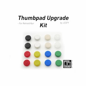 May include: A kit of colorful thumbpad upgrades for Retroid/Ayn consoles. The kit includes black, white, beige, red, yellow, blue, and green thumbpads. The text "Thumbpad Upgrade Kit" is displayed at the top of the image.