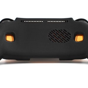 Op de afbeelding: Een zwarte, getextureerde beschermhoes voor een draagbaar spelapparaat. De hoes heeft oranje knoppen en een ventilatieopening. Het ontwerp omvat een getextureerde grip voor verbeterde handling en een goede pasvorm.