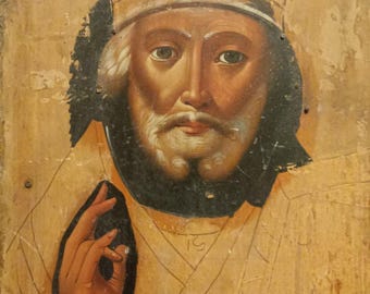 May include: A vintage, hand-painted icon depicting a bearded man wearing a white hat. The icon is painted on a wooden panel and has a worn, aged appearance.