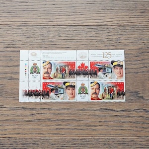 May include: A sheet of 125th anniversary commemorative stamps featuring the Royal Canadian Mounted Police (RCMP). The stamps feature images of RCMP officers in uniform, a Canadian flag, and the RCMP crest. The text "125" and "Royal Canadian Mounted Police" is printed on the stamps.