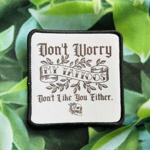 May include: White square patch with black border and text that reads "Don't Worry My Tattoos Don't Like You Either."