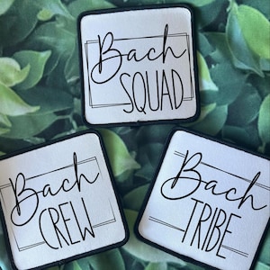 Pode incluir: Três patches quadrados brancos com bordas pretas e texto preto. O texto nos patches diz "Bach Squad", "Bach Crew" e "Bach Tribe".