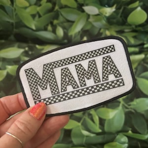May include: White patch with black checkered border and the word "MAMA" in black letters.