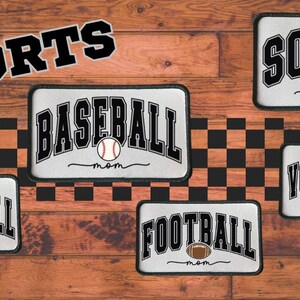 May include: Rectangular sports-themed patches with the words "SPORTS", "SOCCER", "BASEBALL", "BASKETBALL", "FOOTBALL", and "VOLLEYBALL" in black and white. Each patch features a sport-specific ball and the word "mom".