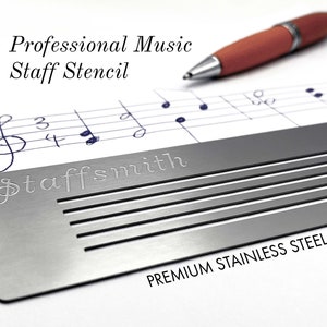 May include: A stainless steel music staff stencil with the word "staffsmith" engraved on it. The stencil is placed over a sheet of music with handwritten notes and a pen. The text "Professional Music Staff Stencil" is at the top.