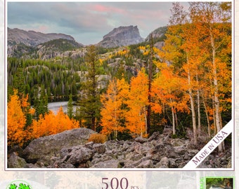 Könnte beinhalten: Ein 500-teiliges Puzzle mit einer malerischen Aussicht auf den Rocky Mountain National Park in Colorado. Das Puzzle zeigt eine Bergkette mit einem See im Vordergrund und einem Wald aus gelben und orangefarbenen Bäumen im Herbst.