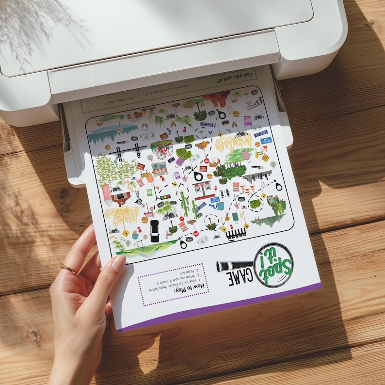 May include: A white paper sheet featuring a Spot It! game with colorful illustrations of various objects, a dashed path, and instructions titled How to Play. The game includes a magnifying glass icon and text, printed from a white printer.