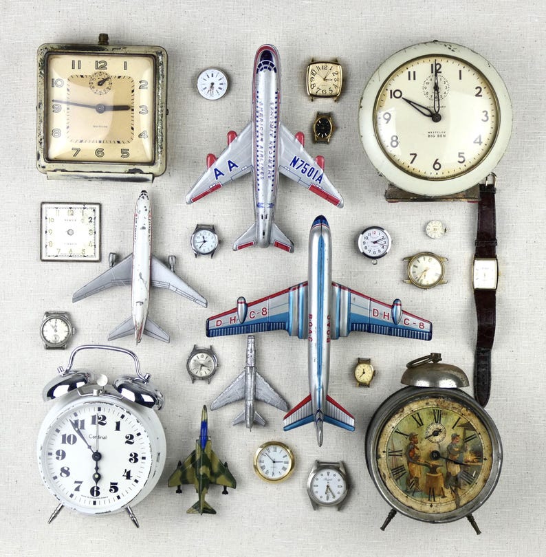 May include: A collection of vintage items including several analog alarm clocks, wristwatches, and die-cast model airplanes. The assortment features a large square clock, a round Westclox Big Ben clock, and various metal aircraft with airline markings.