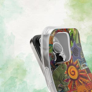 May include: Clear phone case with a colorful, artistic design. The case features a vibrant collage of images, including a green frog, a sun, and a blue star. The design is set against a watercolor background.