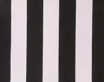 May include: Close-up of a fabric with a bold, vertical stripe pattern. Alternating black and white stripes create a high-contrast design. The fabric's texture is subtly visible, adding depth to the simple, graphic pattern. Ideal for home decor or fashion.