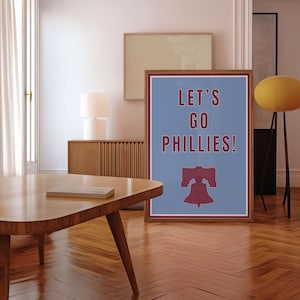 Philadelphia Phillies Baseball Poster in the team's retro or vintage throwback uniform colors maroon red and baby powder blue. States Lets Go Phillies in the maroon red color and the background of the poster is the light blue. A great poster gift for Phillies fans and for kids or children's rooms who want a Philadelphia themed bedroom or game room. Poster comes in a variety of sizes from small sizes to large poster sizes.