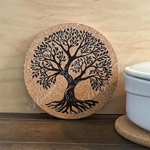 May include: A round cork coaster with a black tree of life design. The coaster is perfect for protecting surfaces from heat.